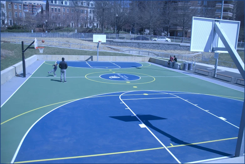 a man stands at the end of a basketball court with his legs crossed