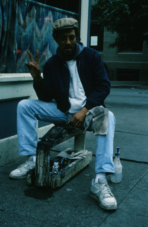 a man sitting on the ground smoking and holding a cigarette