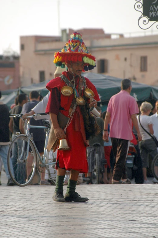 a mexican man wearing a colorful sombrero standing in front of a crowd