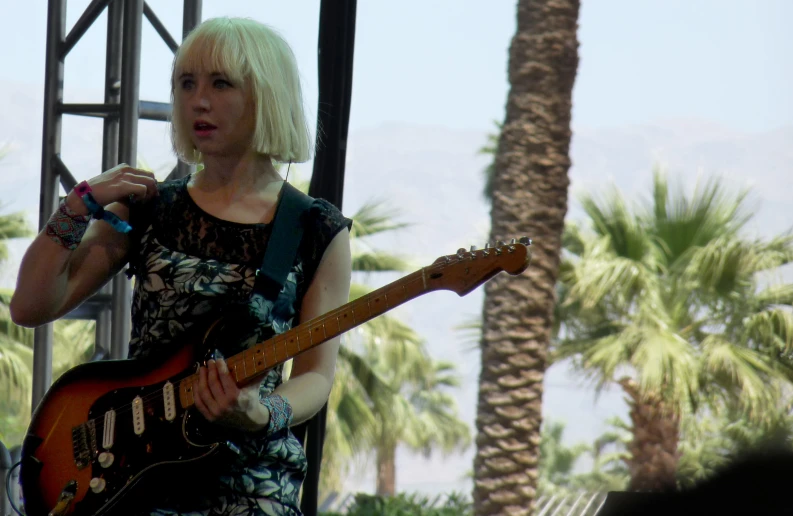 the woman is singing and playing the guitar