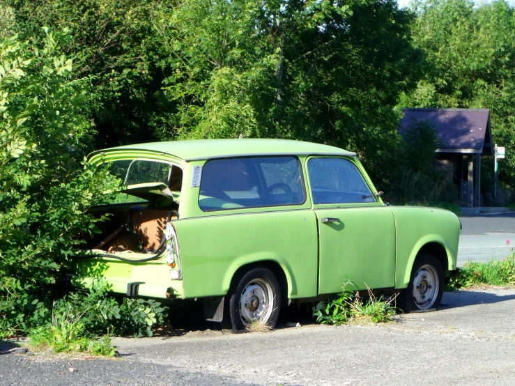 an old car with a small cat in the trunk