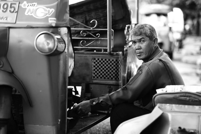 a man that is sitting down in front of a truck