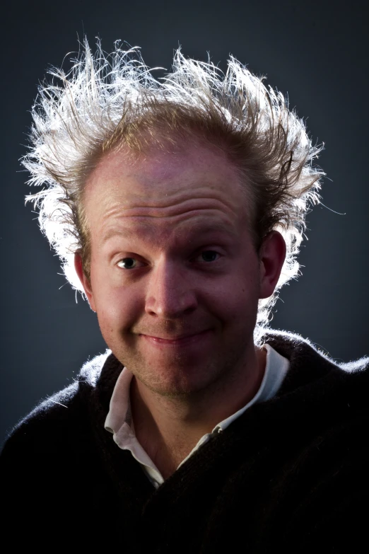 a smiling man with a short white hairdo