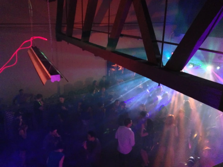 a crowd of people are standing around a bar at a nightclub