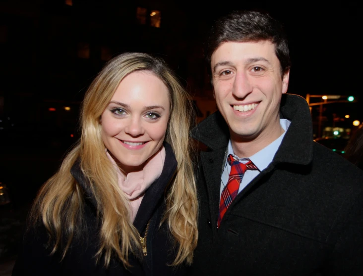 a man standing next to a woman near a building