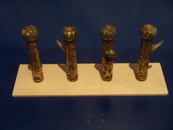 four ornate bronze pieces on a white counter