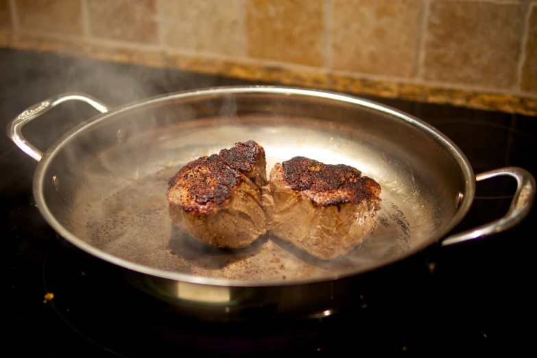 two steaks are being cooked in a set