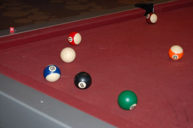 a red pool table that has some pool balls in it