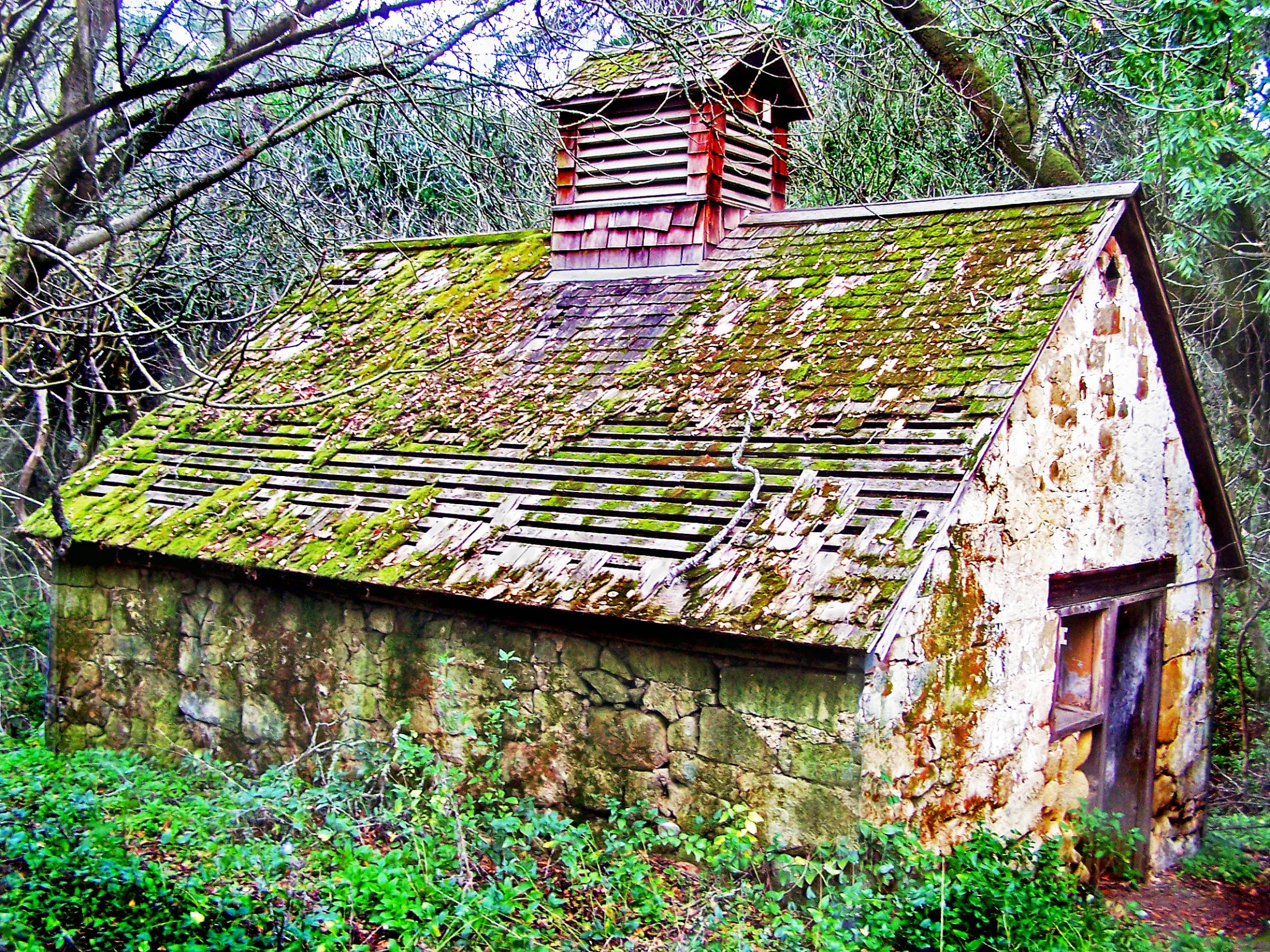 an old, stone building with moss growing on it