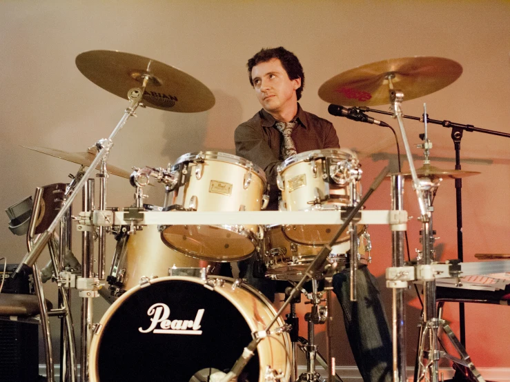 a drummer playing drums in front of a recording equipment set