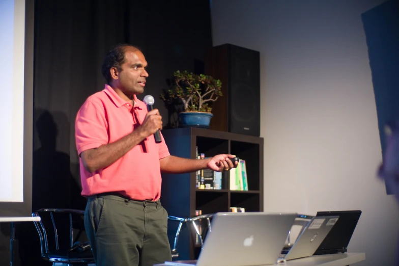 a man standing at a podium and speaking on a microphone