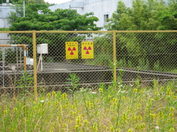 an area with a large fence, some buildings and signs