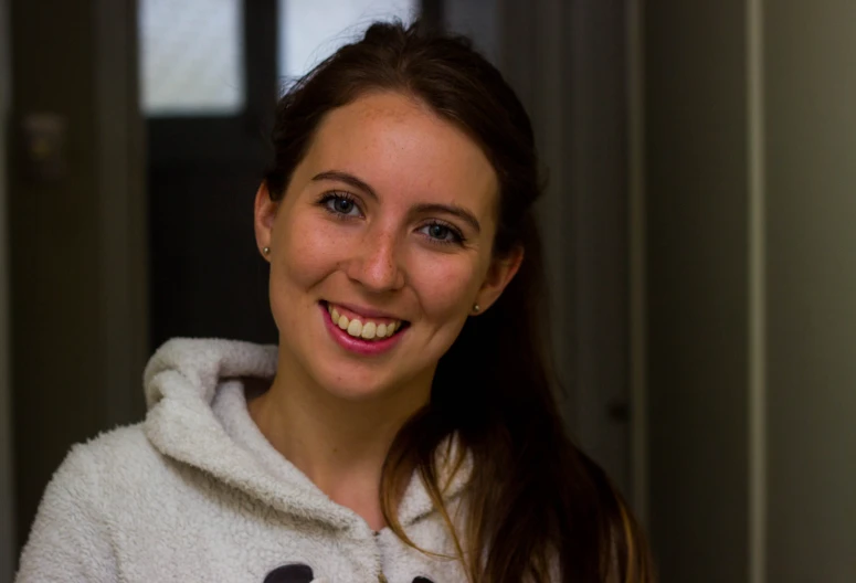 a woman is smiling and wearing a panda bear hoodie