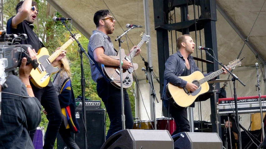 two men with guitars on a stage playing music