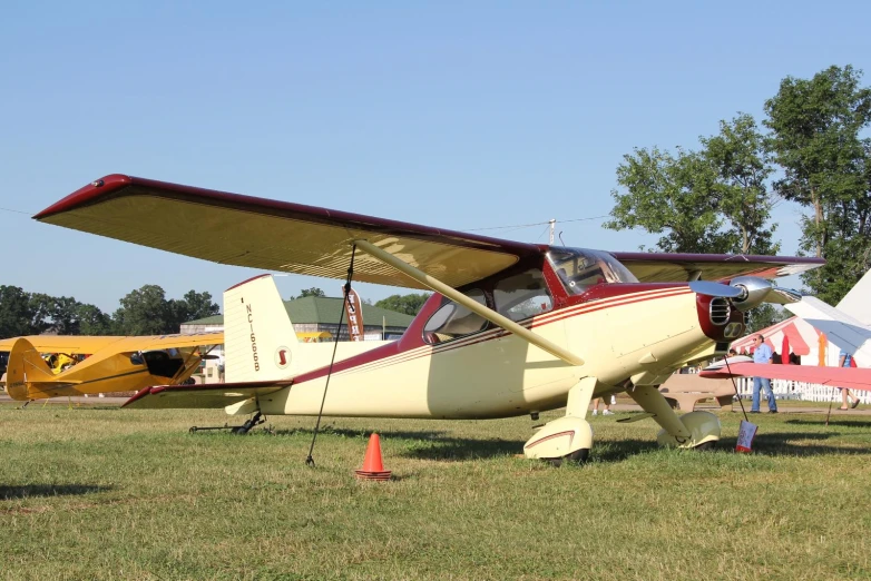 a small yellow airplane parked on top of a field