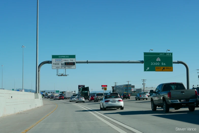 cars driving on a highway next to an exit sign