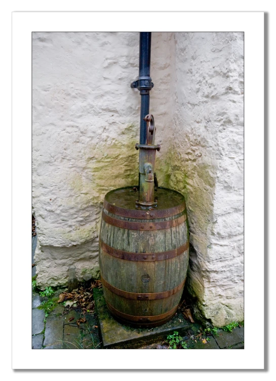 an old fashioned wood barrel has a pump running in it
