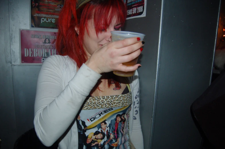 a woman that is holding a cup with red hair