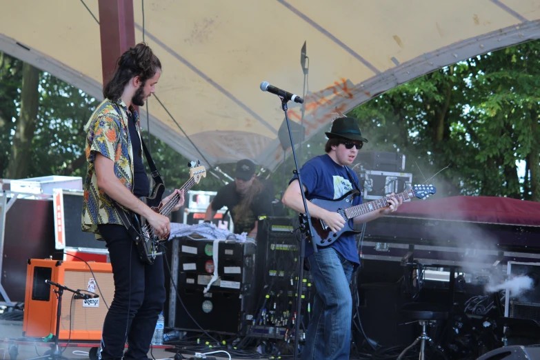 two men playing music under a tent