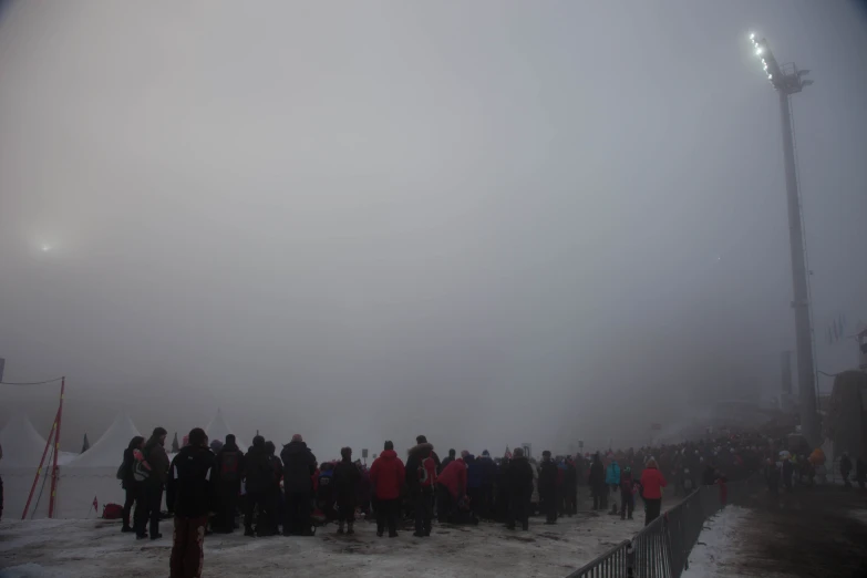 a crowd of people on the snow by a light post