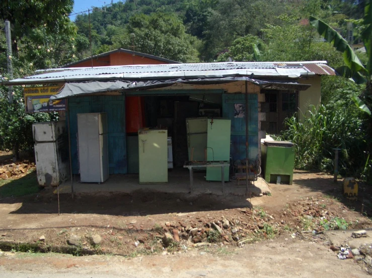 a small building has several refrigerators on the outside