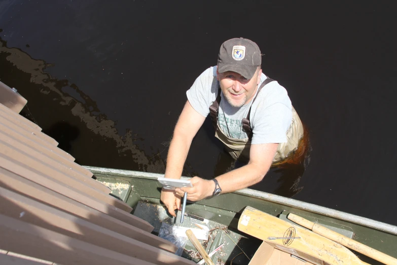 a man is holding some material in his boat