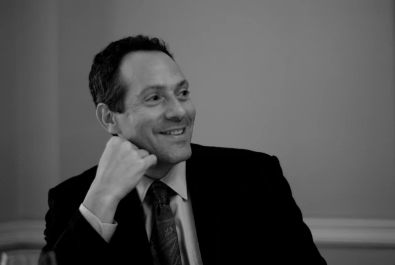 the man is smiling while sitting at a table