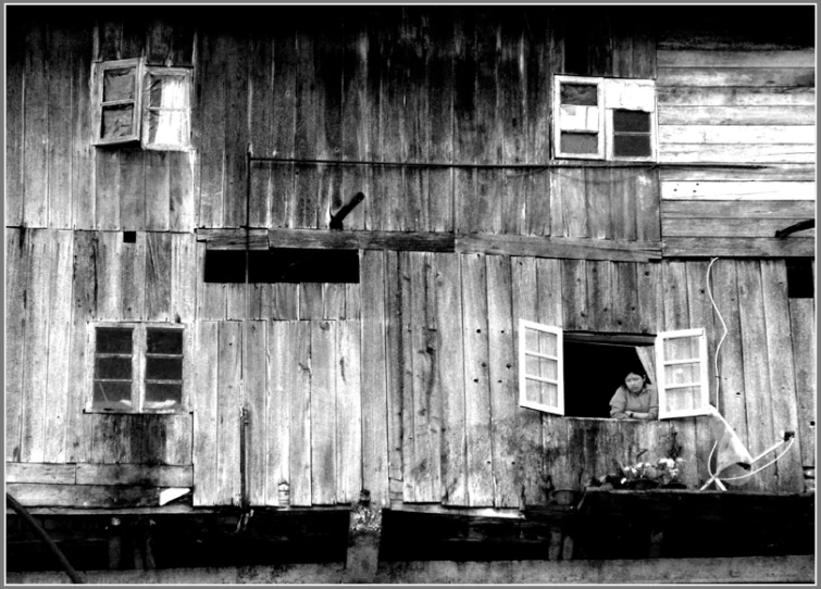 two windows with open shutters on top of a wooden building