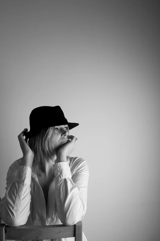 a woman in a hat on top of a chair