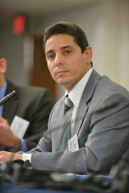 a man in a suit and tie sitting at a table