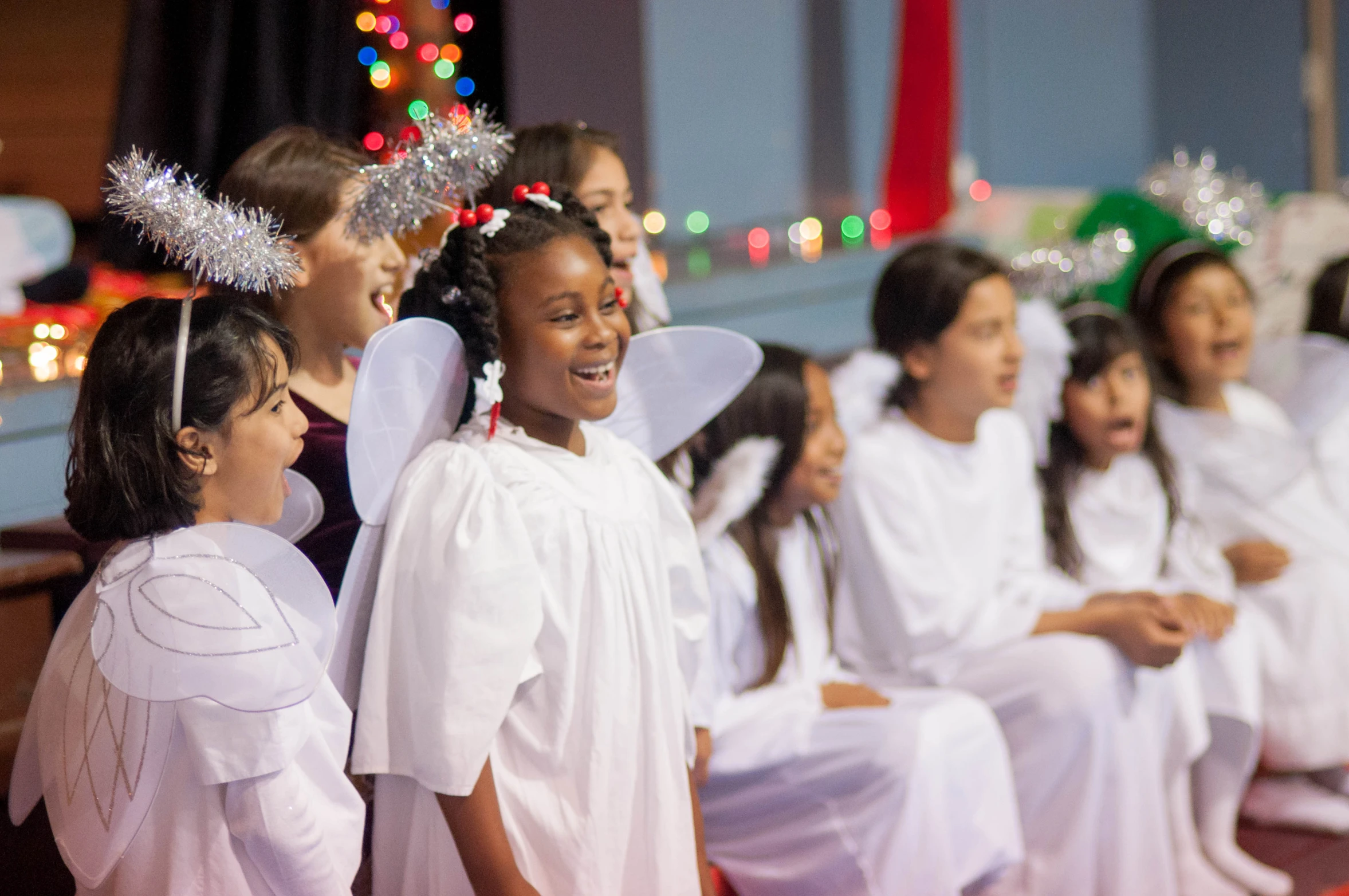 children in white dress wearing angel wings and halos