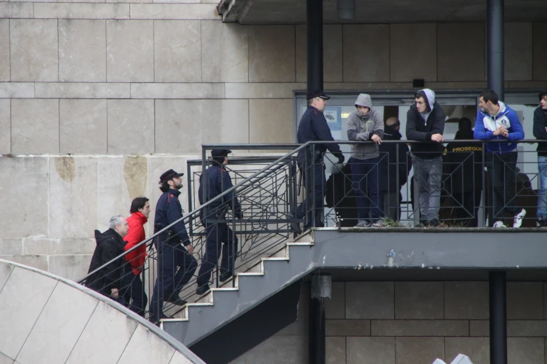 several people walking up a set of stairs, with many wearing coats