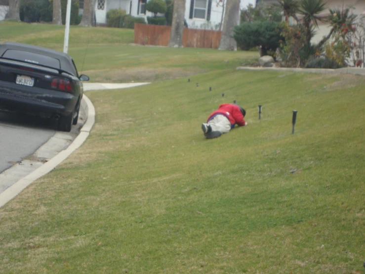 the woman has fallen asleep by the small pole on the grass