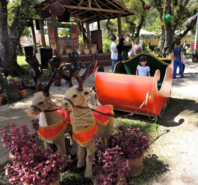 two wooden deer are standing in front of some purple flowers