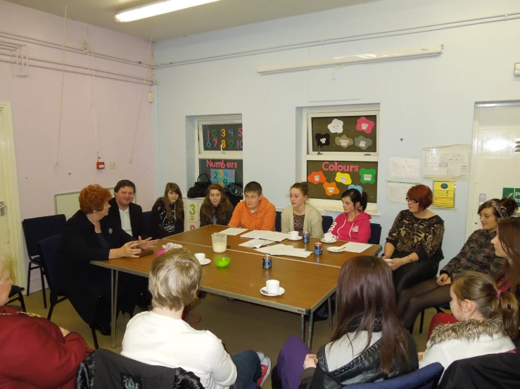 people are gathered around a conference table having lunch