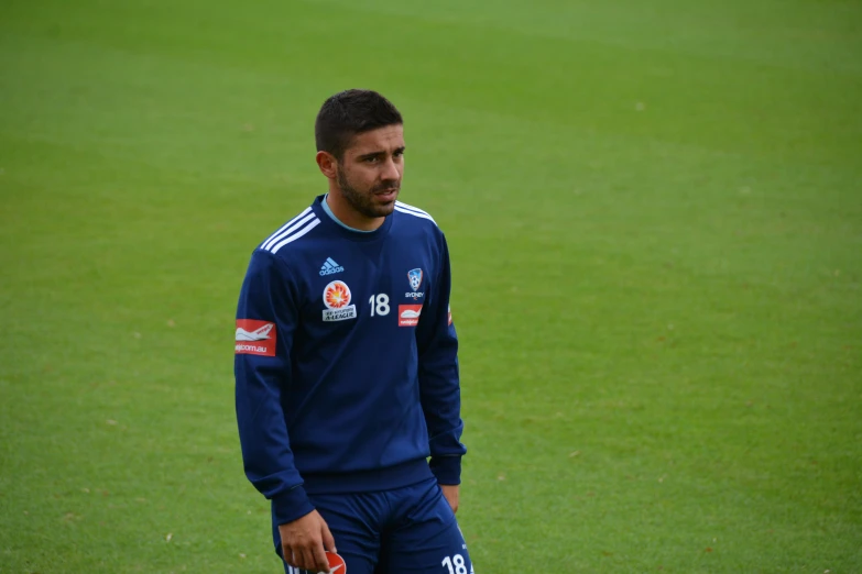 a man wearing a blue soccer jersey standing on a field