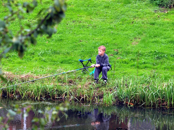 the person is fishing on the shore by the water