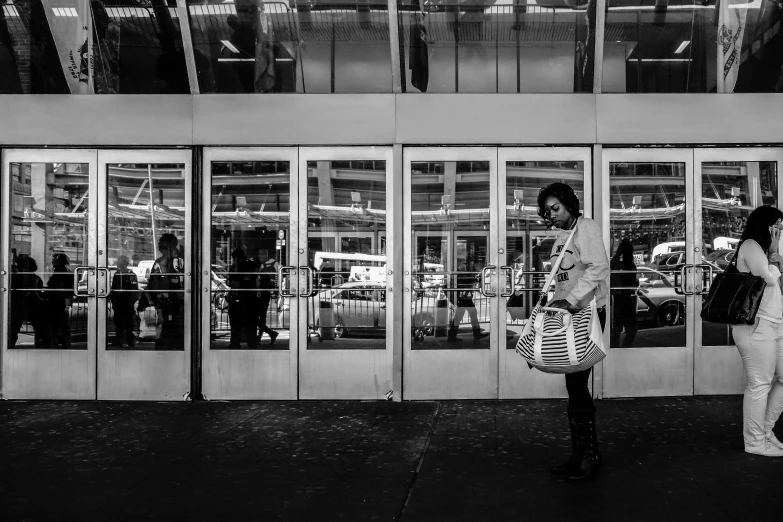 a woman is walking past a large glass door