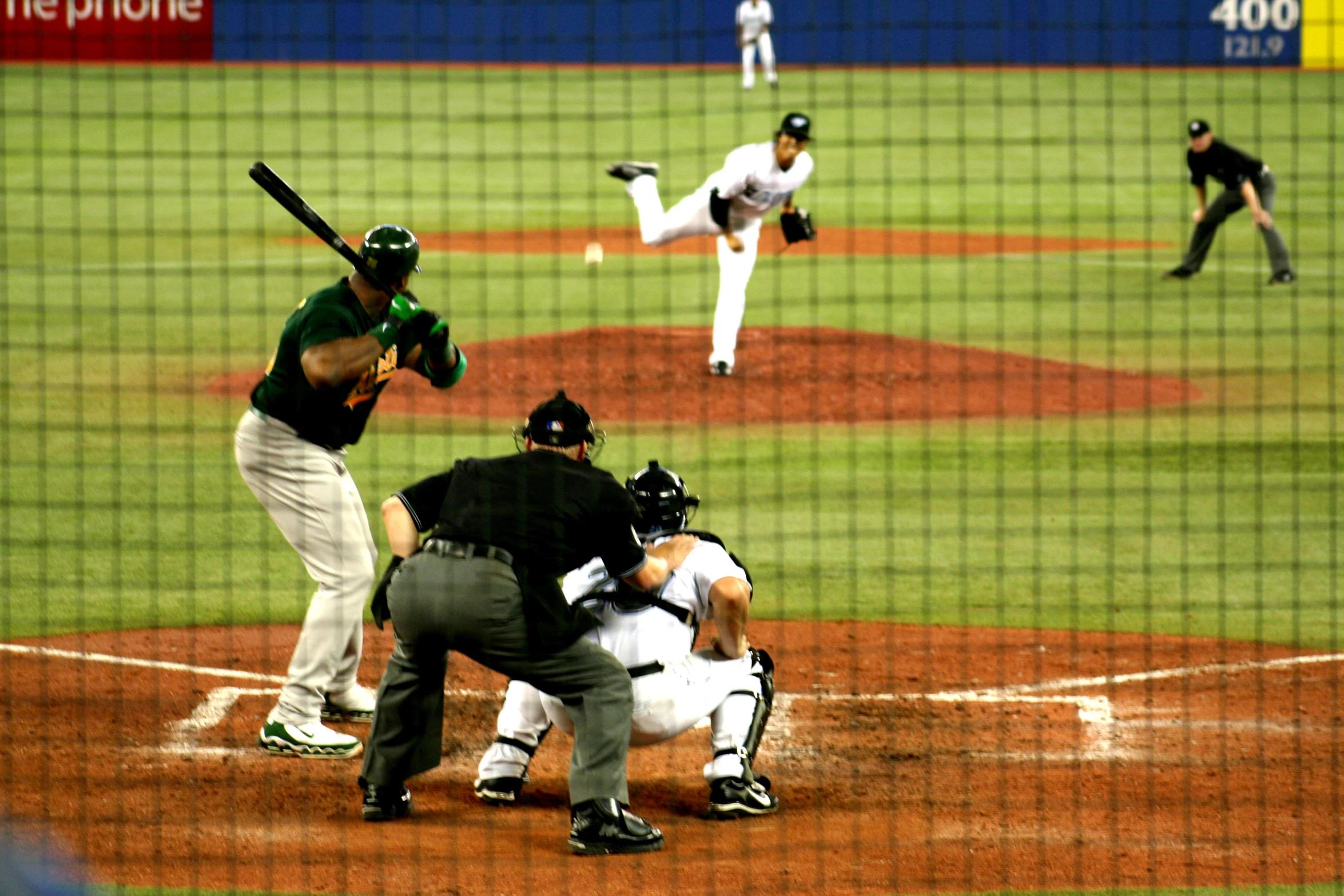 a baseball player throwing a ball to a batter