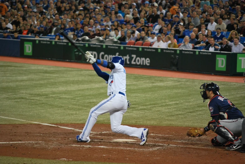 a baseball player is swinging a bat at a baseball