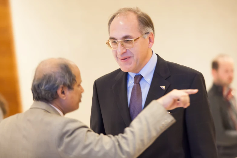 two men wearing suits and ties are talking