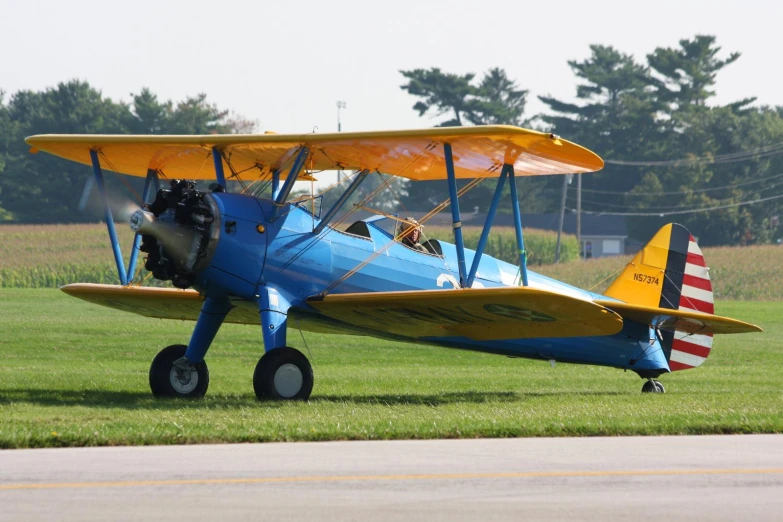 the yellow airplane is sitting on the grass