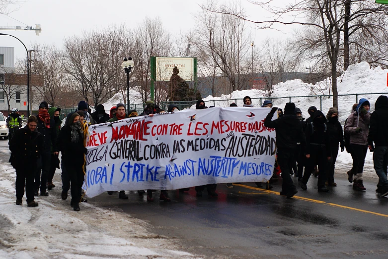 a large group of people walking on the road with signs