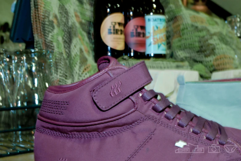 purple shoes on table in room with bottles and cups