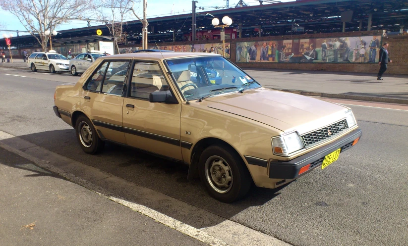 the brown car parked on the side of the road