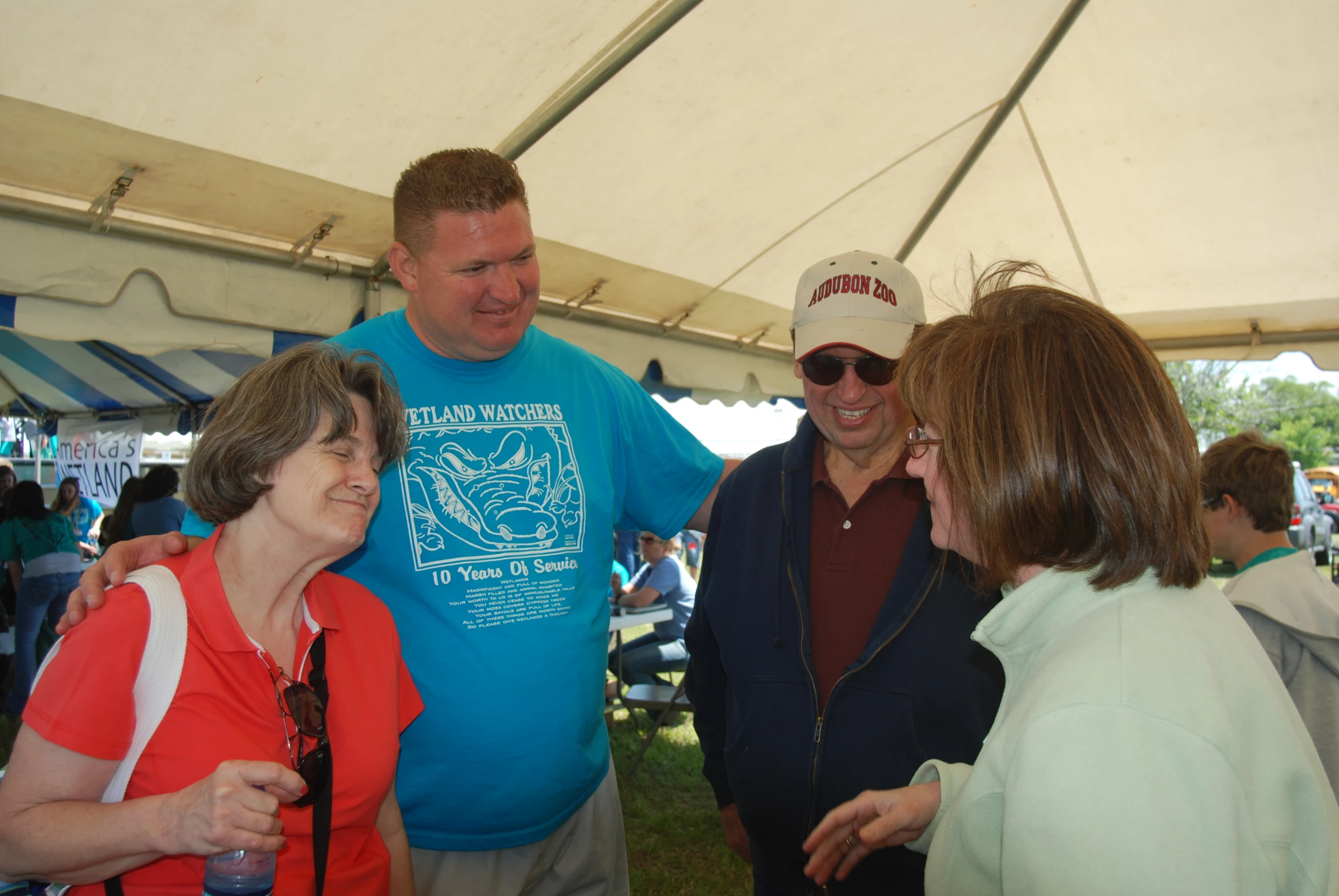 a group of people are talking under a tent