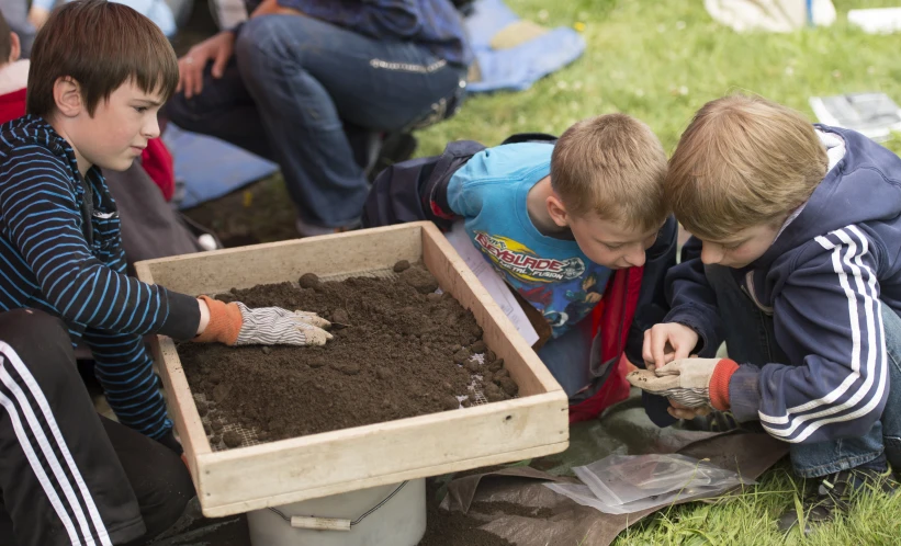 two boys playing with dirt at the park