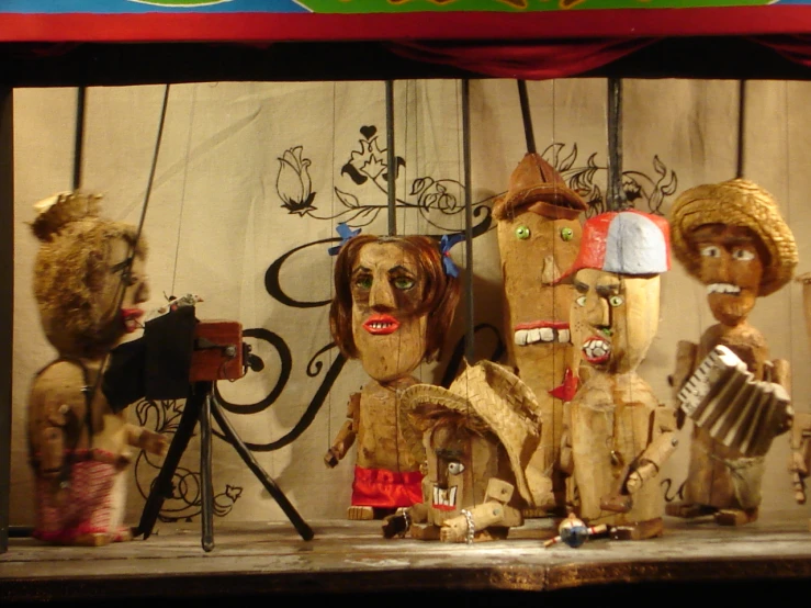 wooden figures on stage with a curtain in background