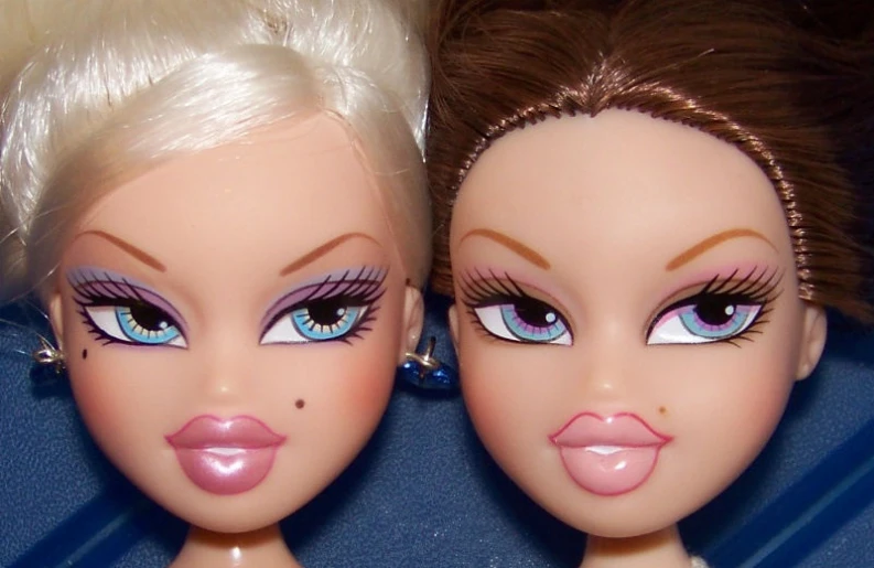 two doll heads with fake lashes and makeup
