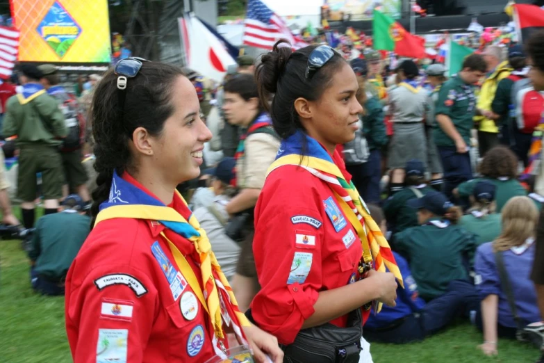 two people in uniforms stand in front of a crowd